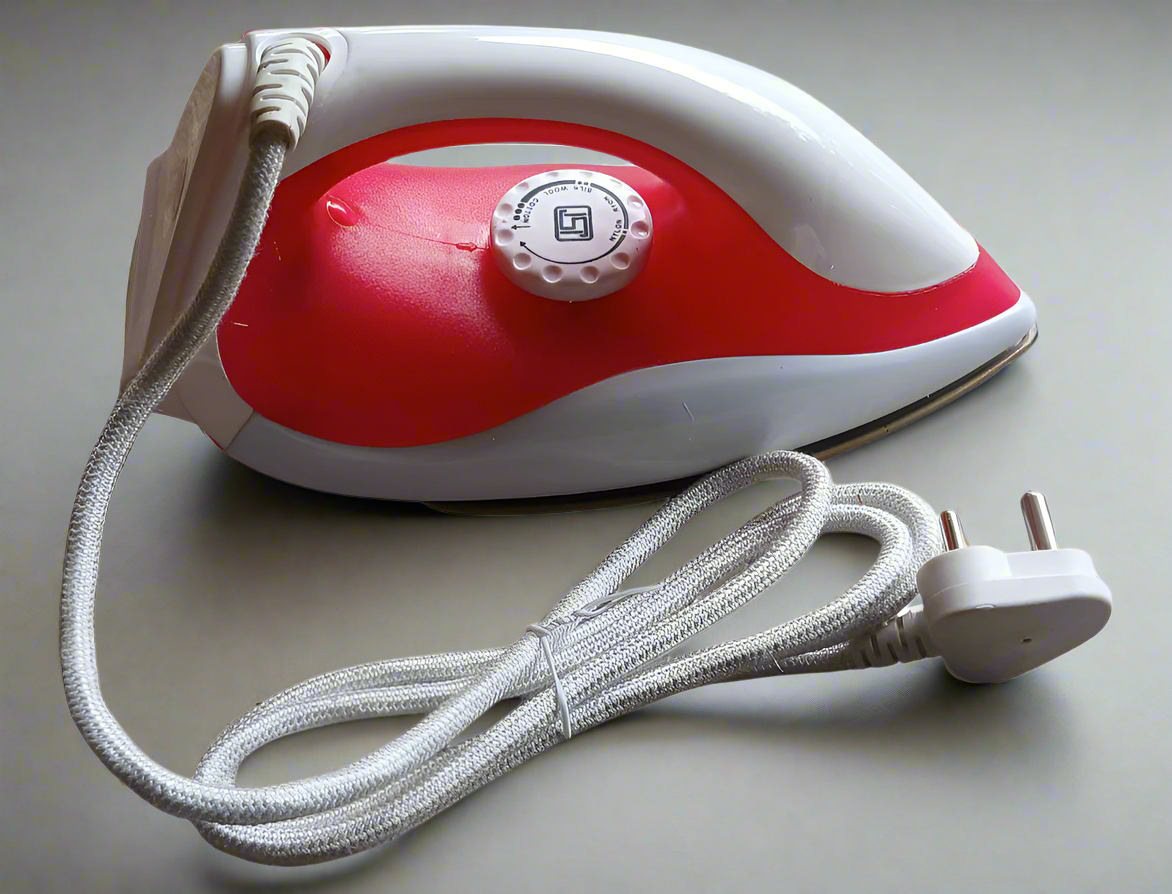 Red and white handheld iron with cord on a white background